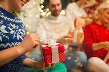 Image showing close up of friends opening christmas gifts