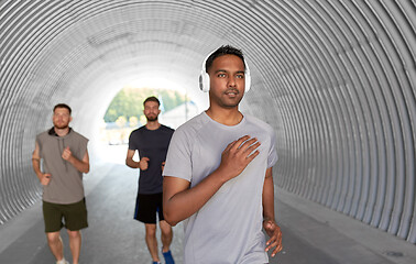 Image showing male friends with headphones running outdoors