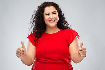 Image showing happy woman in red dress showing thumbs up