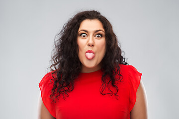 Image showing happy woman in red dress showing tongue