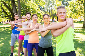 Image showing group of happy people exercising at summer park