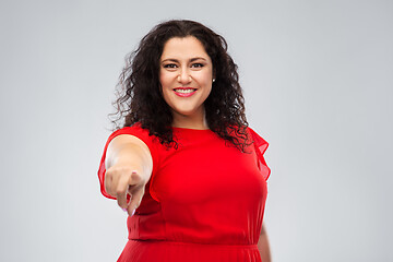 Image showing happy woman in red dress pointing finger to you