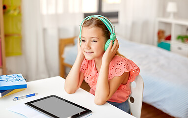 Image showing girl in headphones with tablet computer at home