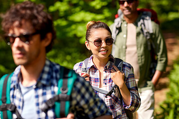 Image showing group of friends with backpacks hiking in forest