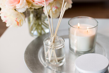 Image showing aroma reed diffuser, candle and flowers on table