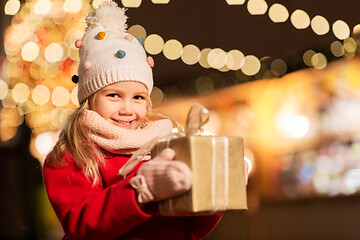 Image showing happy girl with gift box at christmas market