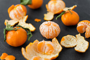 Image showing close up of peeled mandarins on slate table top