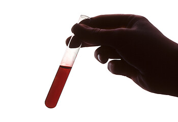 Image showing Hand holding test tube of red liquid against white