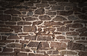 Image showing Old masonry wall using irregular stones lit from above