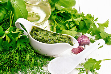 Image showing Sauce of spicy greens in gravy boat on white board