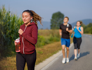 Image showing young people jogging on country road