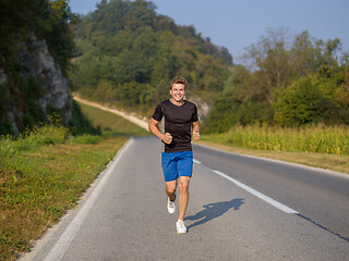 Image showing man jogging along a country road