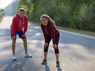 Image showing young couple warming up and stretching on a country road