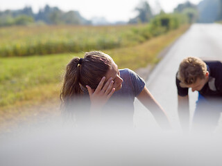 Image showing young couple warming up and stretching on a country road