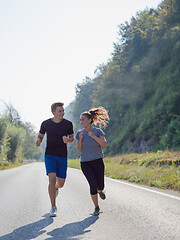 Image showing young couple jogging along a country road