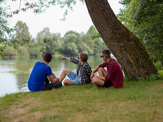 Image showing men sitting on the bank of the river