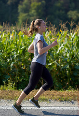 Image showing woman jogging along a country road