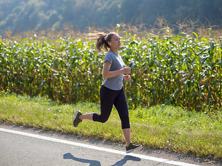 Image showing woman jogging along a country road