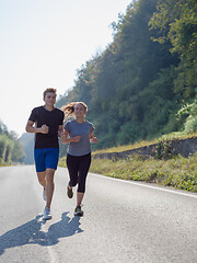 Image showing young couple jogging along a country road