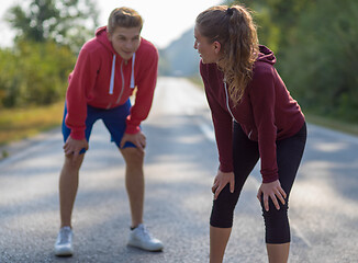 Image showing young couple warming up and stretching on a country road