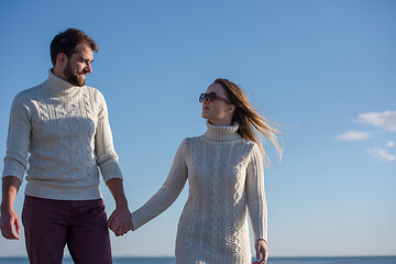 Image showing Loving young couple on a beach at autumn sunny day