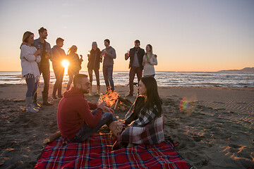 Image showing Couple enjoying with friends at sunset on the beach