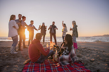 Image showing Couple enjoying with friends at sunset on the beach