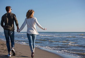 Image showing Loving young couple on a beach at autumn sunny day