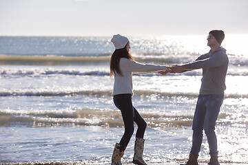 Image showing Loving young couple on a beach at autumn sunny day