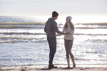 Image showing Loving young couple on a beach at autumn sunny day