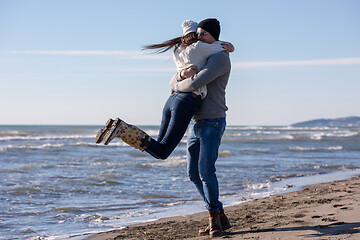 Image showing Loving young couple on a beach at autumn sunny day