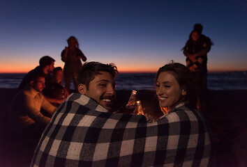 Image showing Couple enjoying with friends at sunset on the beach