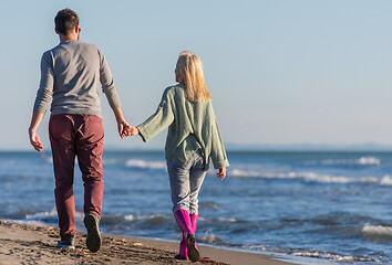 Image showing Loving young couple on a beach at autumn sunny day