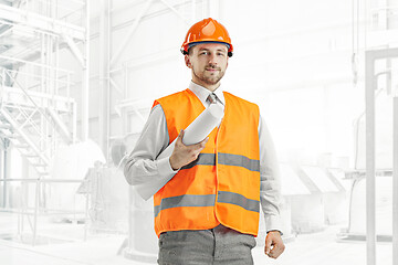 Image showing The builder in orange helmet against industrial background