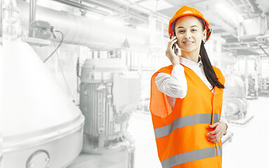 Image showing Destroying gender stereotypes. Female builder standing against industrial background