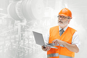 Image showing The builder in orange helmet against industrial background