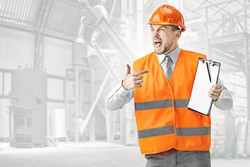 Image showing The builder in orange helmet against industrial background