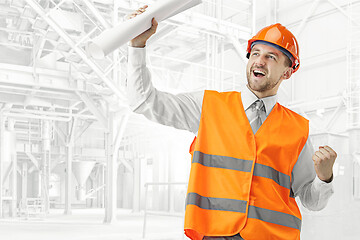 Image showing The builder in orange helmet against industrial background
