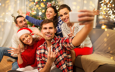 Image showing friends celebrating christmas and taking selfie