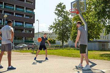 Image showing group of male friends playing street basketball