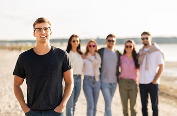 Image showing happy man with friends on beach in summer