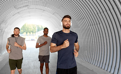 Image showing male friends with headphones running outdoors