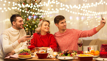 Image showing friends taking selfie at christmas dinner