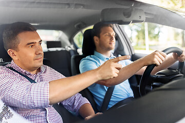 Image showing car driving school instructor teaching male driver