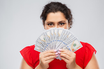 Image showing woman hiding her face behind money banknotes