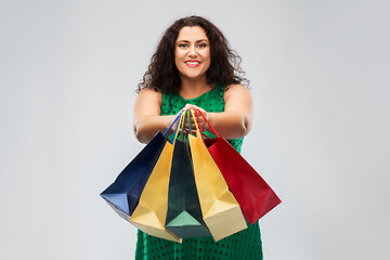 Image showing happy woman in green dress with shopping bags