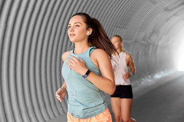 Image showing women or female friends with earphones running