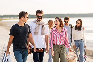 Image showing happy friends walking along summer beach