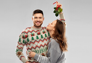 Image showing happy couple kissing under the mistletoe