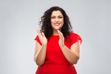 Image showing happy woman in red dress applauding